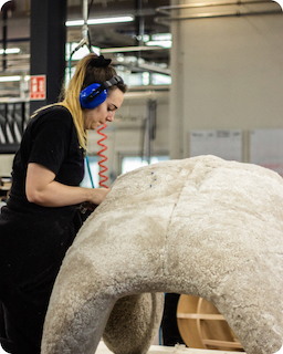 A woman works in the manufacturing of a giant plushie
