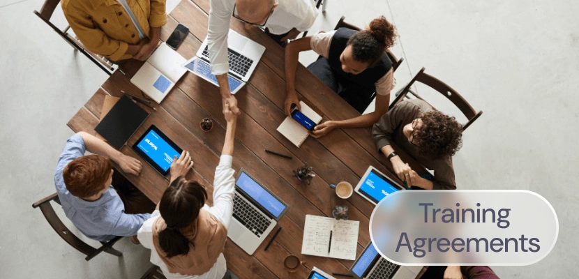 A group of employees around the table with the label: Training Agreements