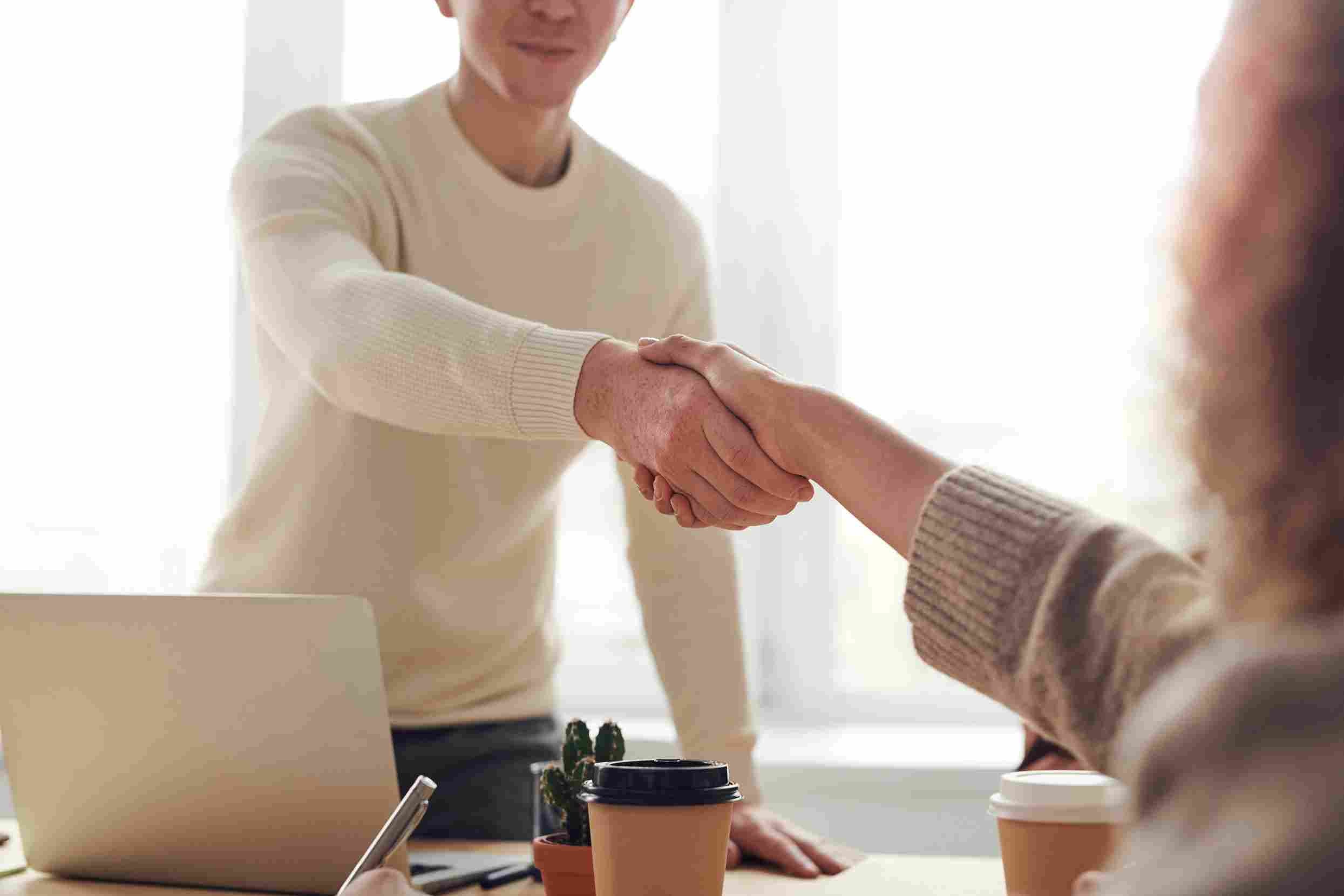 An individual shakes the hand of the hiring manager as he accepts a new job. The hiring manager is concerned he may become bored easily in his new role.